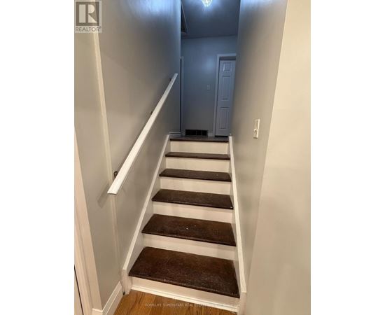 A staircase with white railings and brown steps.