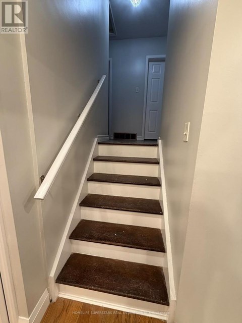 A staircase with white railings and brown steps.