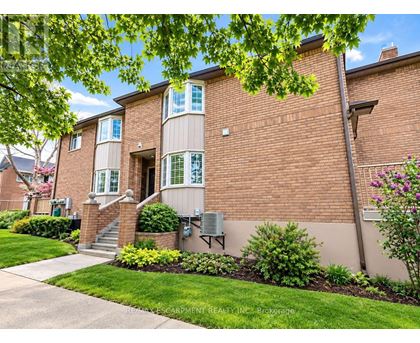 A brick apartment building with a green lawn in front.