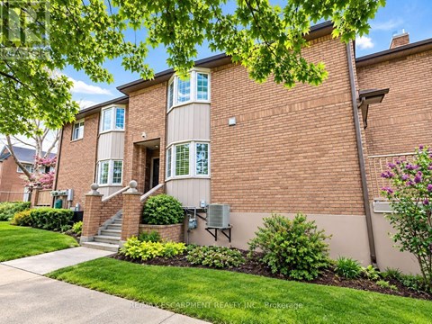 A brick apartment building with a green lawn in front.