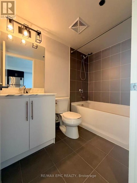 A bathroom with a white toilet, white bathtub, and white cabinet.