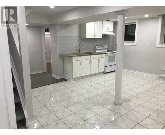 A kitchen with white cabinets and a white tile floor.