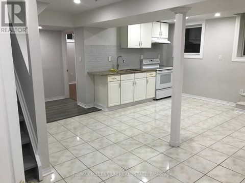 A kitchen with white cabinets and a white tile floor.