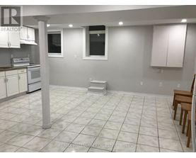 A white tiled kitchen with a dining table and chairs.