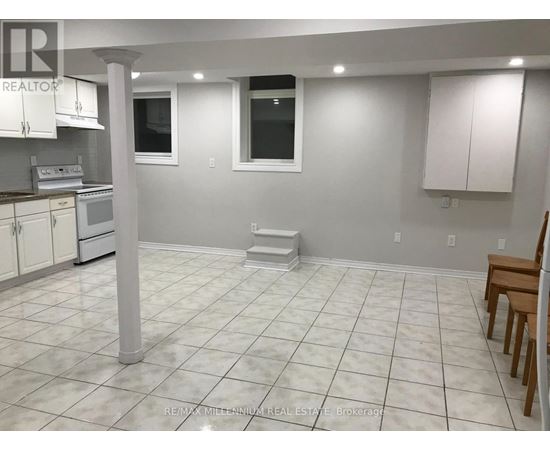A white tiled kitchen with a dining table and chairs.