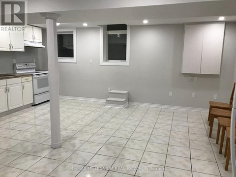 A white tiled kitchen with a dining table and chairs.