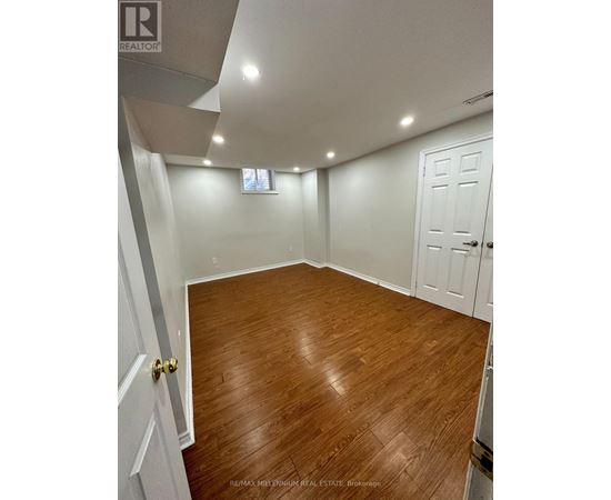 A room with wooden flooring and white walls.