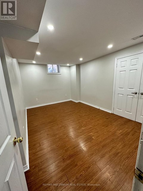 A room with wooden flooring and white walls.