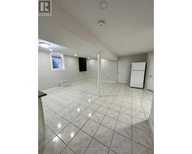 A large empty room with white tile flooring and white walls.