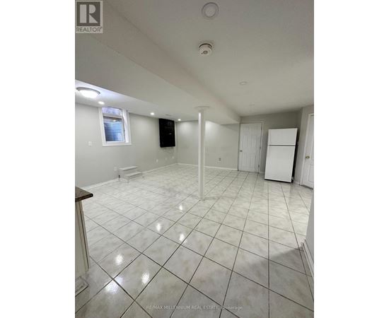 A large empty room with white tile flooring and white walls.