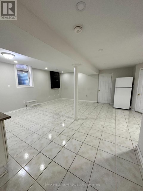 A large empty room with white tile flooring and white walls.
