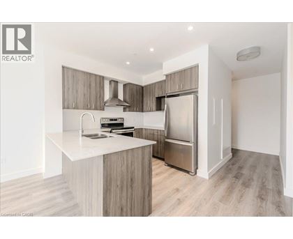 A modern kitchen with a white countertop and stainless steel appliances.