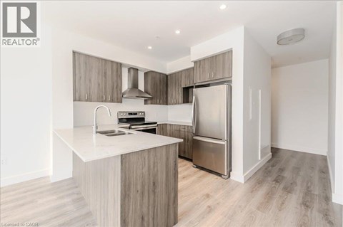 A modern kitchen with a white countertop and stainless steel appliances.