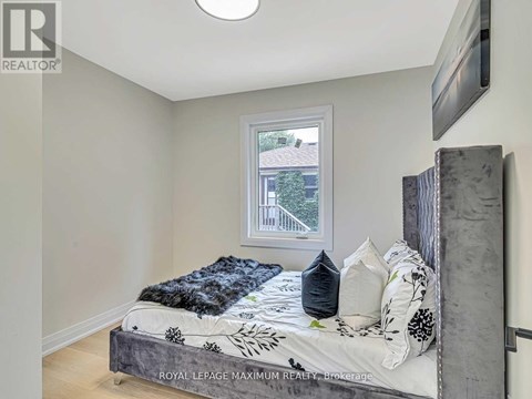 A bedroom with a bed and a window.