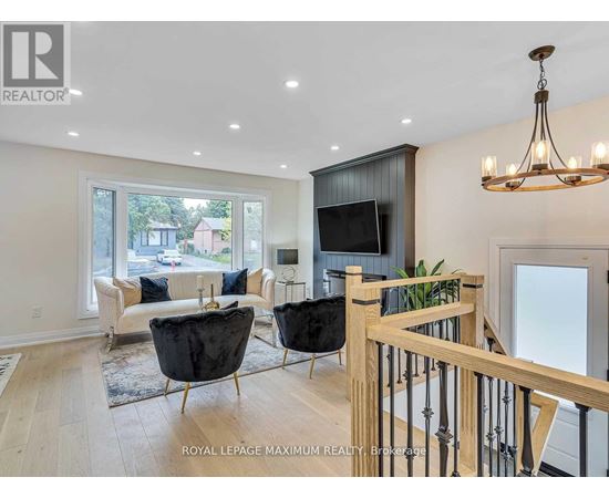 A living room with a black leather chair and a wooden railing.