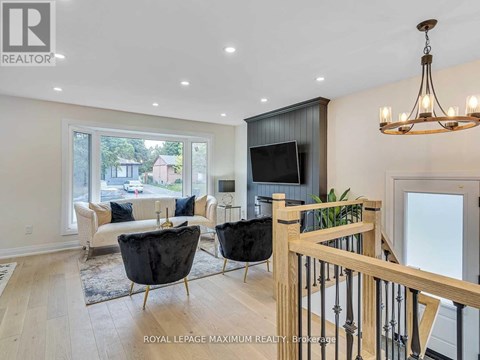 A living room with a black leather chair and a wooden railing.