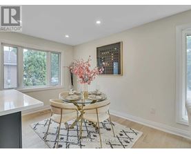 A dining room with a round glass table and chairs.