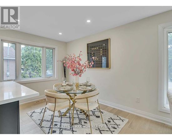 A dining room with a round glass table and chairs.