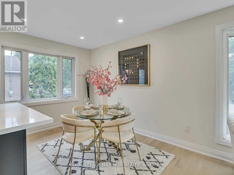 A dining room with a round glass table and chairs.