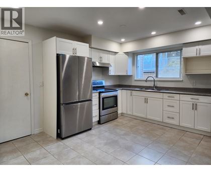 A kitchen with a refrigerator, oven, and microwave.