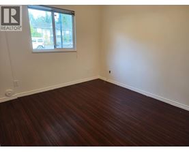 A room with a window and wooden flooring.