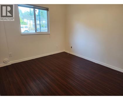 A room with a window and wooden flooring.
