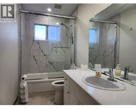 A bathroom with marble tiles and a white sink.