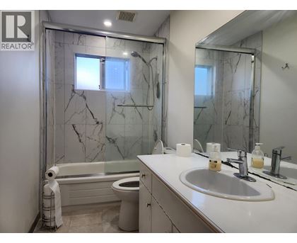 A bathroom with marble tiles and a white sink.