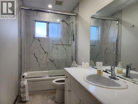 A bathroom with marble tiles and a white sink.