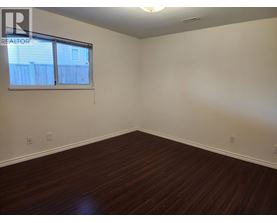 A room with a window and wooden flooring.