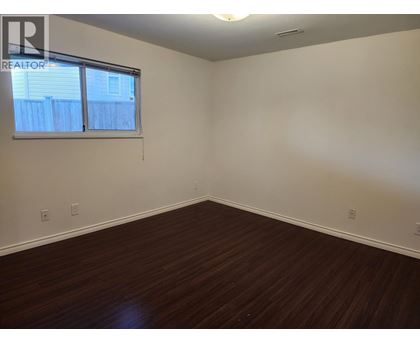 A room with a window and wooden flooring.