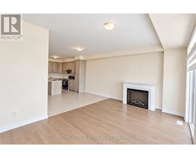 A spacious living room with a fireplace and wooden flooring.