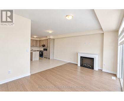 A spacious living room with a fireplace and wooden flooring.