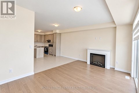 A spacious living room with a fireplace and wooden flooring.