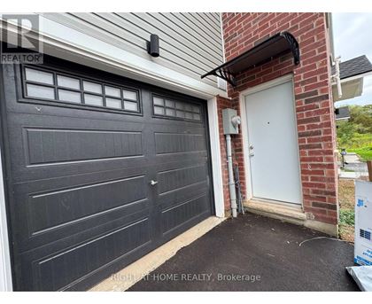 A black garage door is closed and there is a white door to the right of the garage.