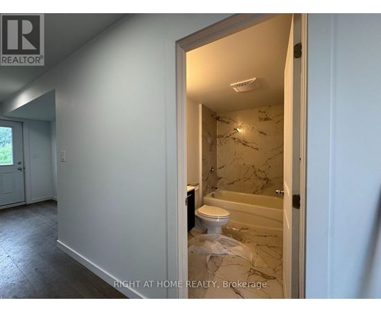 A bathroom with a toilet and a bathtub in a room that is under renovation.