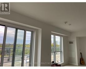 A room with a view of the outside through large windows.