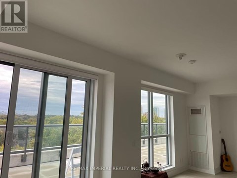 A room with a view of the outside through large windows.