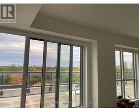 A room with a large window overlooking a parking lot.