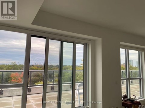 A room with a large window overlooking a parking lot.
