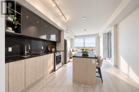 A modern kitchen with dark cabinets and a wooden island.