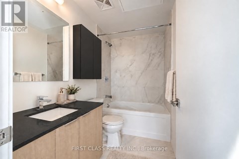 A bathroom with a white toilet and a white bathtub.