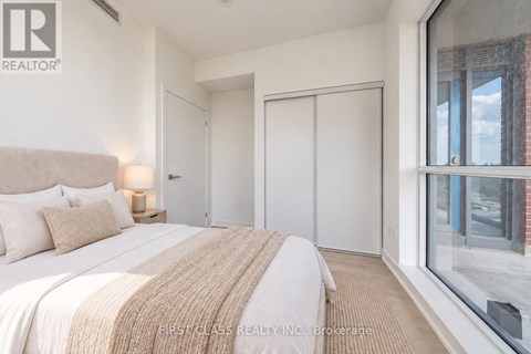 A bedroom with a large bed and a window overlooking a street.