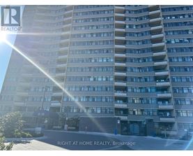 A tall residential building with the sun shining on it.