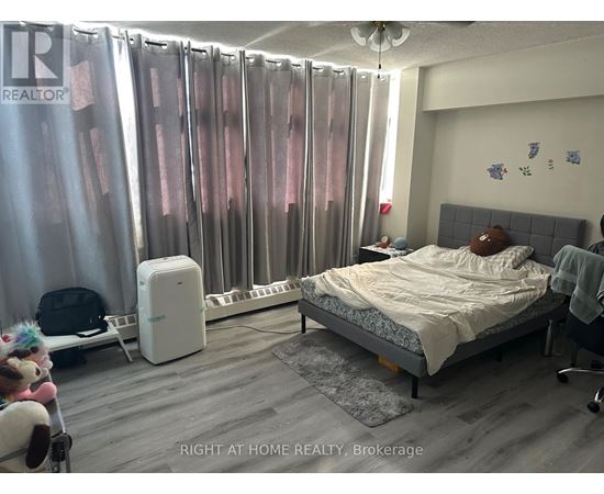A bedroom with a bed, chair, and curtains.