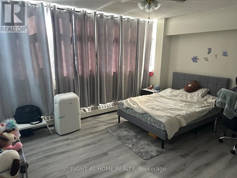 A bedroom with a bed, chair, and curtains.