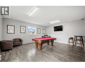 A room with a pool table and a tv mounted on the wall.