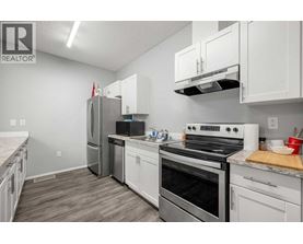 A kitchen with white cabinets and stainless steel appliances.