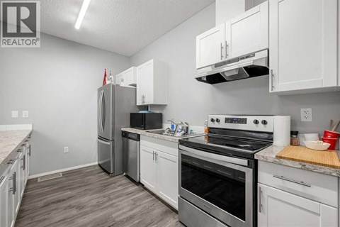 A kitchen with white cabinets and stainless steel appliances.