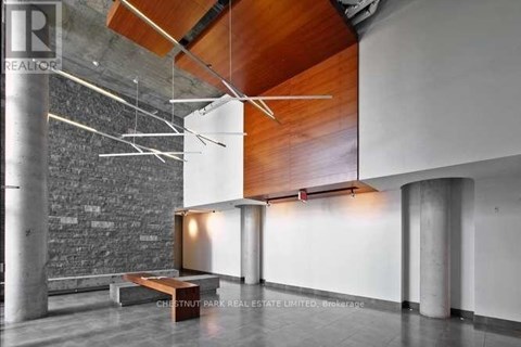 A modern interior space with a bench, a wall, and a ceiling with wooden beams.